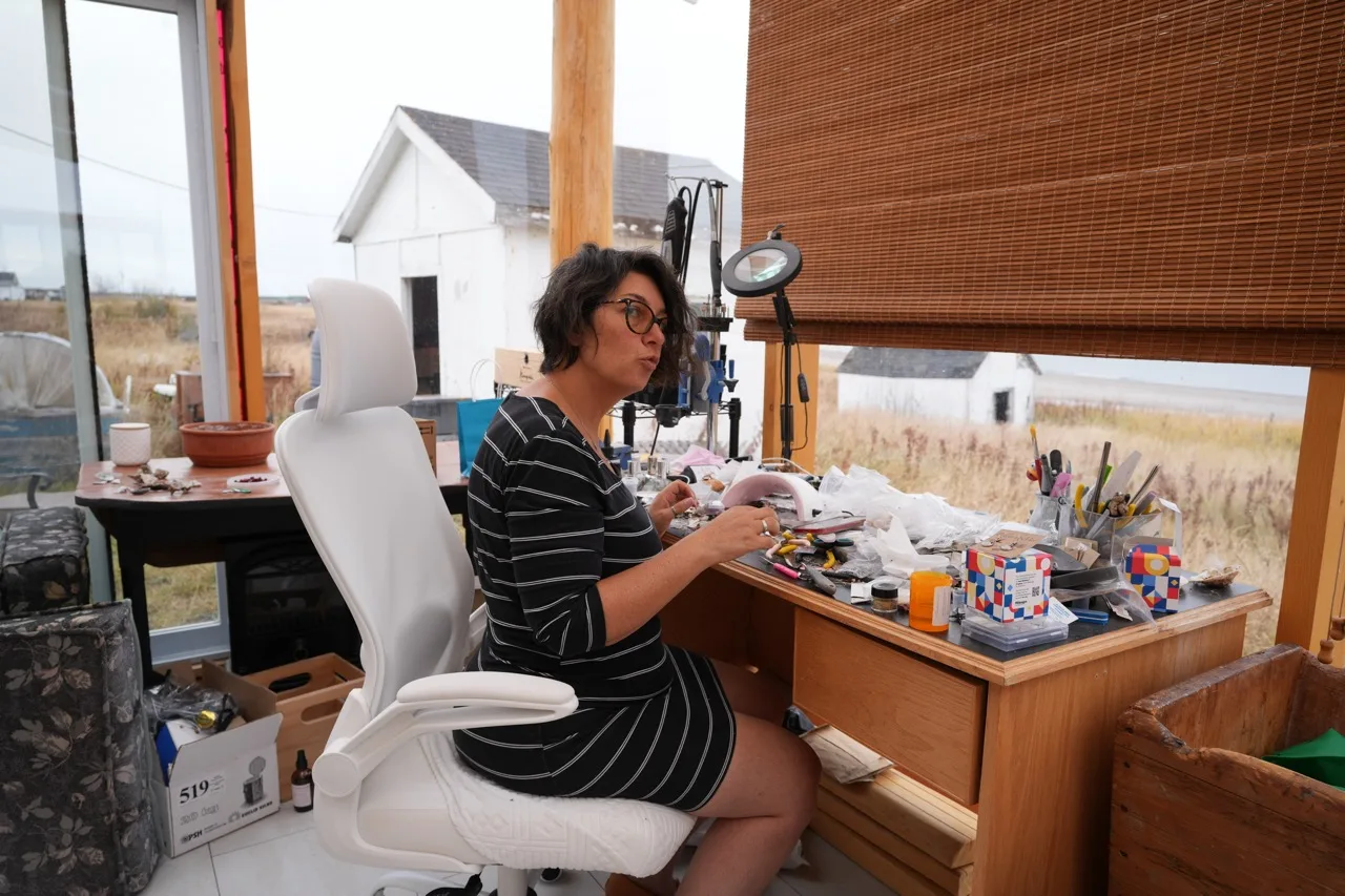 Karyn Vignola à sa table de travail, dans son atelier vitré donnant sur la mer